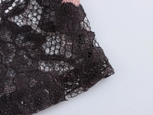 Detailed close-up of intricate black lace floral pattern and mesh texture on women shirt