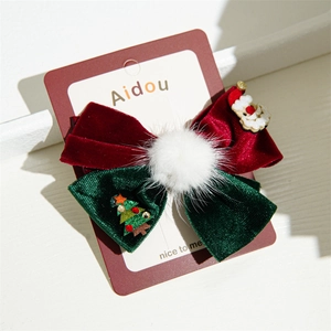 Detail of Christmas bow hair clip with velvet fabric and festive cartoon charms