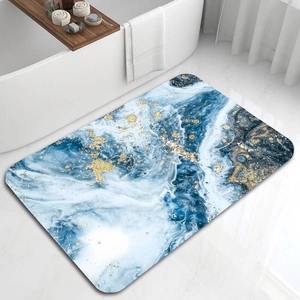 Dettaglio del tappeto da bagno con motivo marmorizzato blu e oro accanto a una vasca da bagno
