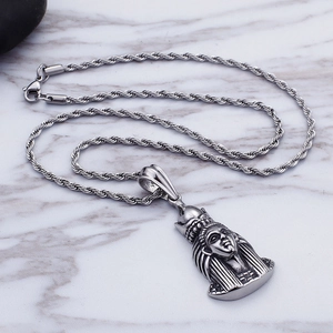 Macro shot of silver twisted chain and ancient Egyptian pharaoh head pendant jewelry