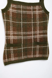 Detailed close-up of a plaid knit vest featuring brown and green checkers and pockets