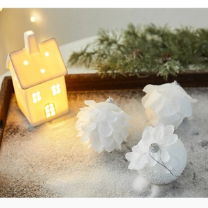 Detailed close-up of three white petal-textured Christmas foam balls on a snowy tray