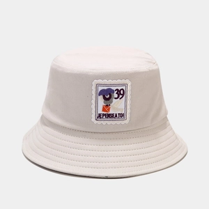 Detail shot of beige canvas bucket hat with embroidered stamp patch and french text