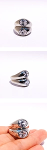 Macro detail of silver double-layer wide band ring with large round cubic zirconia stones