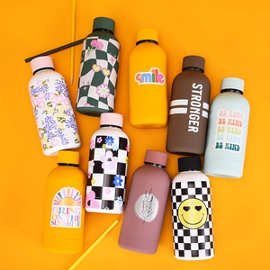 Flat lay of colorful stainless steel water bottles with floral and checkerboard patterns