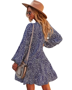Detail view of the back of a blue and white polka dot dress with ruffled hem and V-neck