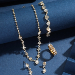 Dettaglio di un set di gioielli scintillanti in strass dorati su elegante sfondo blu