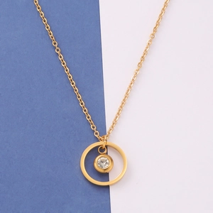 Close-up of golden geometric necklace with a clear round zircon stone pendant