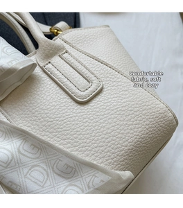 Close-up of beige lychee grain leather bucket bag with elegant monogrammed silk scarf wrap