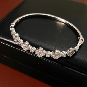 Detail of silver clover bangle with cubic zirconia on black leather jewelry box