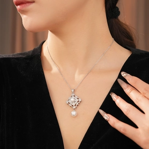 Close-up of pearl necklace with vintage filigree pendant and zircon accents on model
