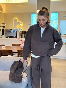 Deep brown half-zip sweatshirt set with drawstring trousers in a cozy cafe setting