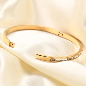 Detalle de la pulsera de acero inoxidable dorado con circonitas de corte cuadrado