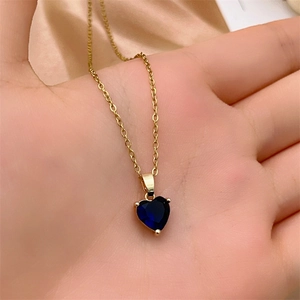 Detail showing the deep blue heart zircon pendant and polished gold-plated chain