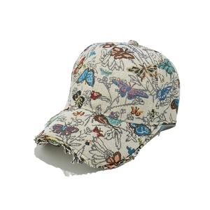 Detailed close-up of distressed brim with colorful butterfly embroidery on baseball cap
