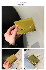 Detail view of a gold metallic envelope wallet with mirror finish and stitching