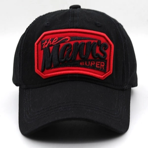 Detailed close-up of retro Mann's SUPER embroidery patch on a black cotton baseball cap
