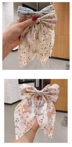 Detailed view of large floral chiffon bow hair clips in various vibrant colors and patterns