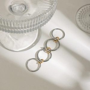 Détail de bagues multicouches argent et or avec pierres de zircon et ombres rythmées