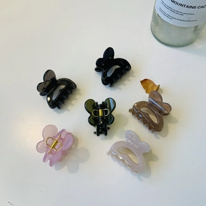 Vue à plat de six pinces à cheveux papillon en couleurs assorties avec ressorts robustes