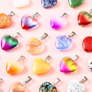 Various 20mm heart-shaped natural stone pendants with silver metal clasps on pink background