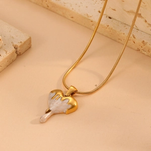Detail of gold heart pendant with white drip oil effect on sleek snake chain