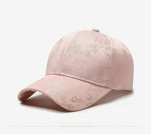 Detailansicht einer rosa Baseballkappe mit floraler Stickerei und glänzendem Stoffgewebe