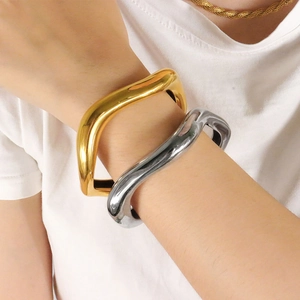Minimalist irregular metal bangle set with polished wavy surface in gold and silver finish