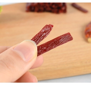 Macro shot of hand-held miniature PVC beef jerky for DIY dollhouse food accessories