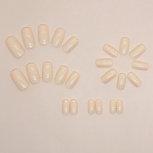 Glossy cream yellow medium square press-on nails set in a minimalist flat lay arrangement