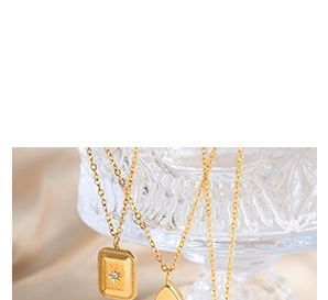 Detail of gold constellation necklaces with crystal pendants on a glass holder