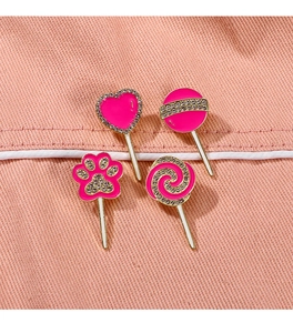 Detail of pink enamel heart and cat paw brooches with rhinestones on denim fabric