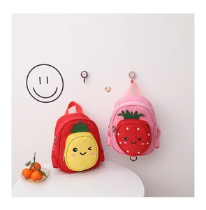 Detail view of colorful canvas kids backpacks with cute pineapple and strawberry designs