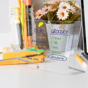 Clear acrylic weekly planner board on desk with metal stand and colorful to-do lists