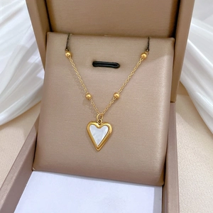 Detail of gold heart pendant with white mother of pearl inlay on jewelry box