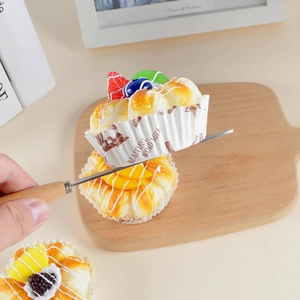 Realistic PU cake models with fruit toppings and server tool on wooden board