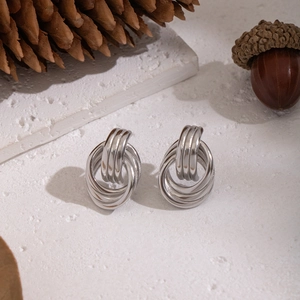 Boucles d'oreilles circulaires argentées sur pierre blanche avec des accents d'automne