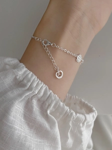 Detailed view of S925 silver bracelet featuring snowflake and peace sign pendants