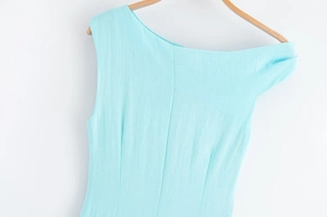 Vue détaillée de la texture de la robe sans manches bleu clair sur un cintre en bois naturel