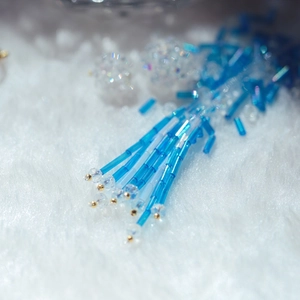 Close-up of blue Czech glass column beads and crystal spacer beads in an earring