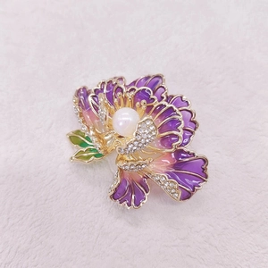 Macro detail of enamel peony brooch with purple petals, zircon edges and a center pearl