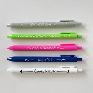 Detail of five retractable gel pens in matte pastel colors with motivational English quotes