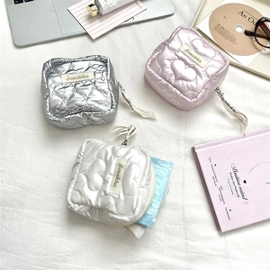 Detail of heart-quilted square pouch with metal zipper and letter-printed ribbon puller