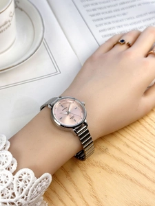 Close-up of pink dial quartz watch with silver metal strap on female wrist