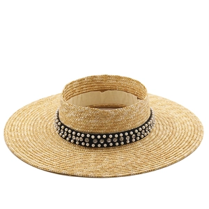 Detail of hand-woven wheat straw boater hat with pearl and rhinestone trim headband