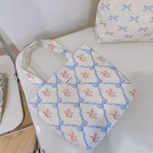 Close-up of floral canvas tote bag featuring blue ribbon lattice and pink rose patterns
