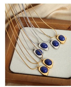 Macro shot of geometric gold and silver necklaces with blue natural stone pendants