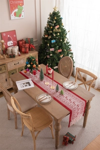 Festive red Christmas table runner with elk and snowflake patterns and tassel edges