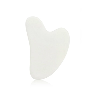 Detailed view of a white heart-shaped resin facial massage tool on a plain white background