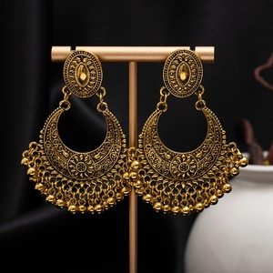 Detail of vintage bohemian tassel earrings with hollow flowers and antique gold finish
